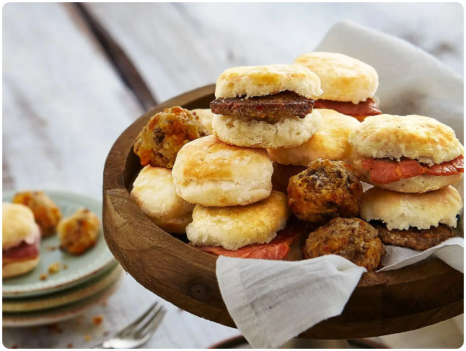 A basket of fresh biscuits and sausage balls.